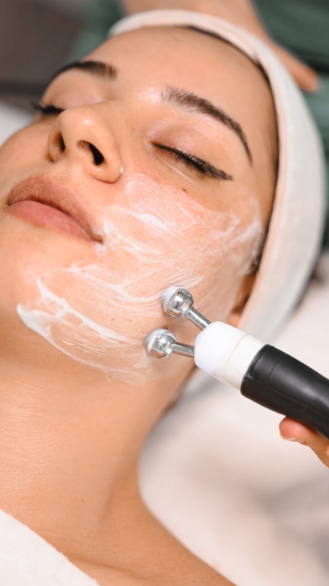 Massager Spreading Face Cream across Womans Face